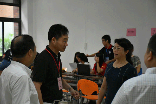 学校副董事长谢少华与院长万世明交谈（谢少华（右二）万世明（左二））