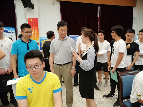 万世明院长（第二排中）在招聘会现场和企业代表交流.png